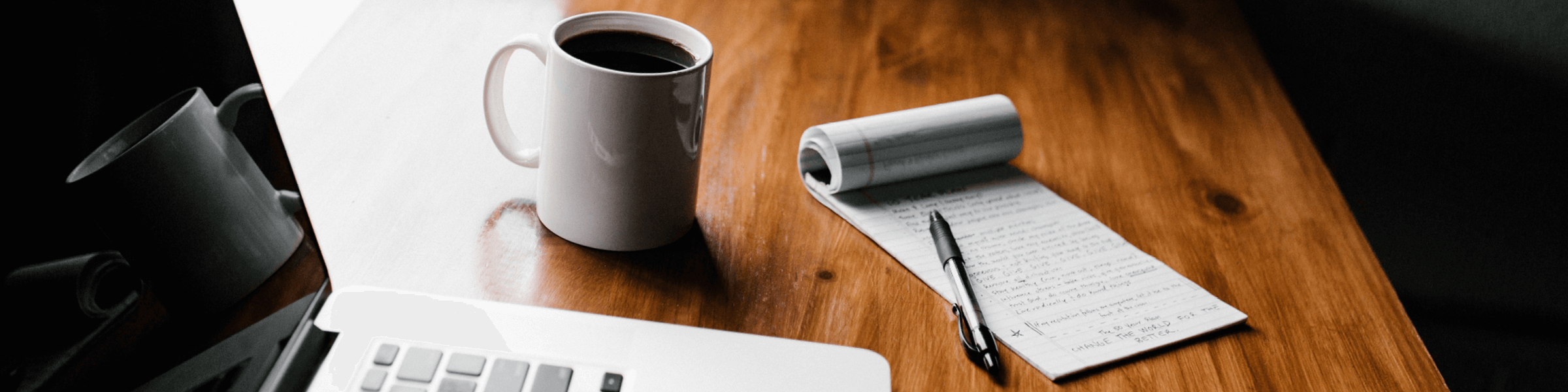 An employee desk with a computer and cup of coffee.