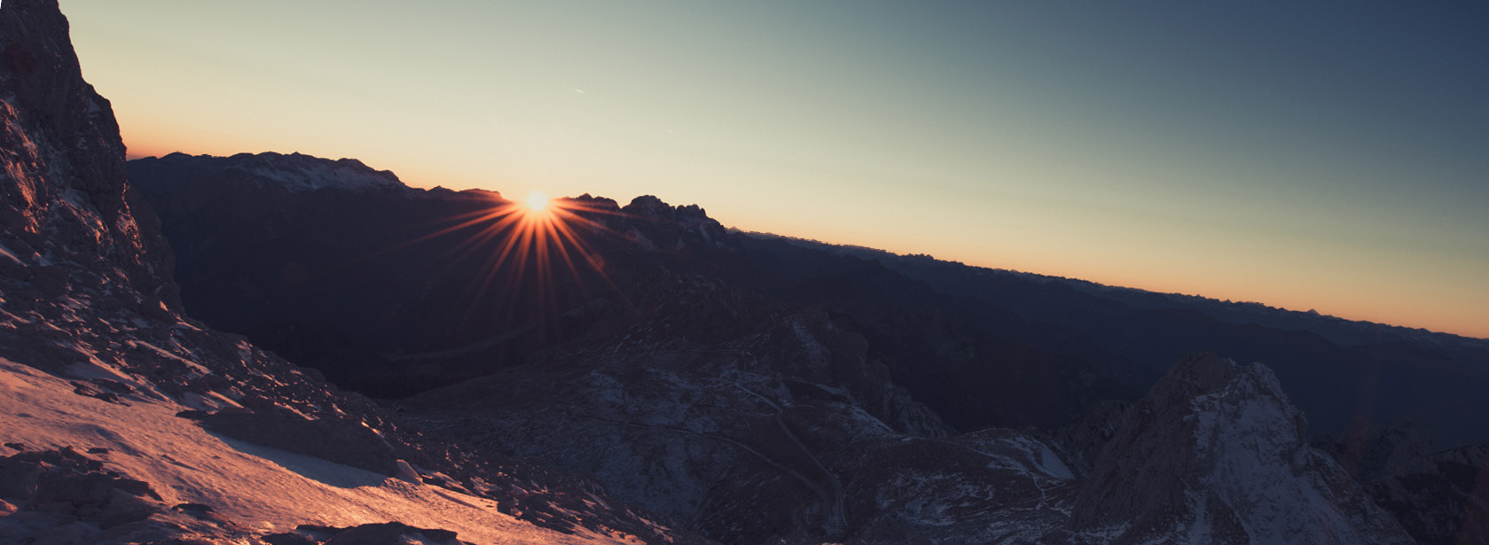 A sun rising over a mountain.