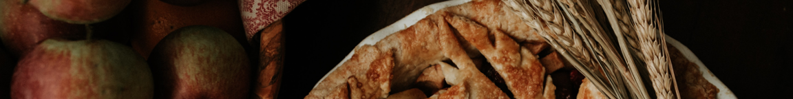 A pie and apples on a table.