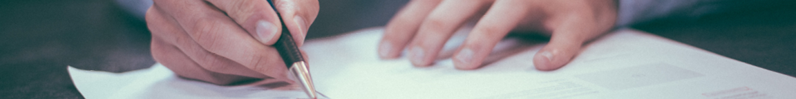 Hands writing on a document.