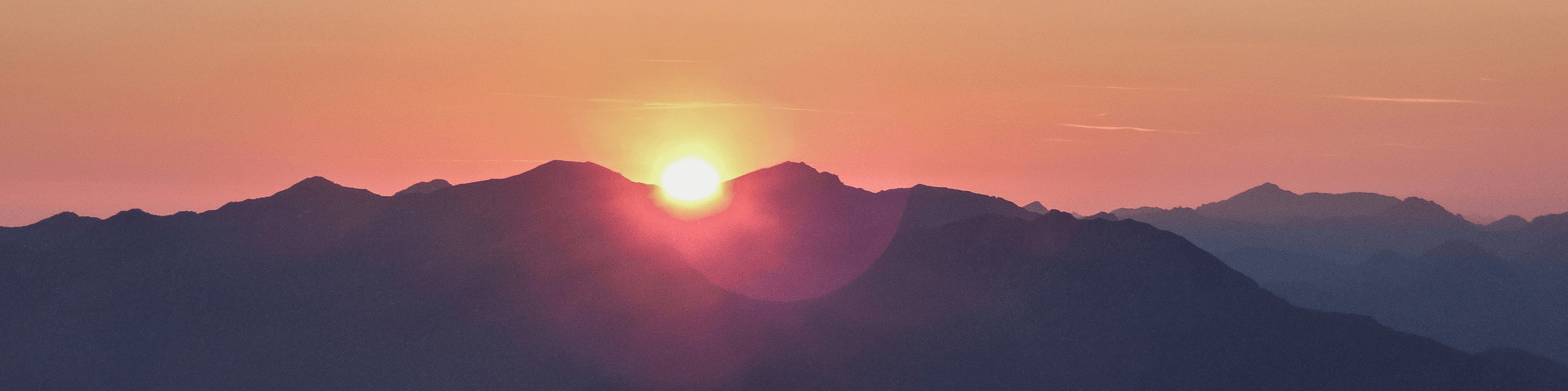 A sun setting over a mountain.