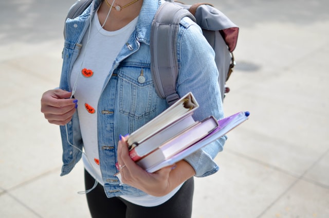 A student holding books. 
