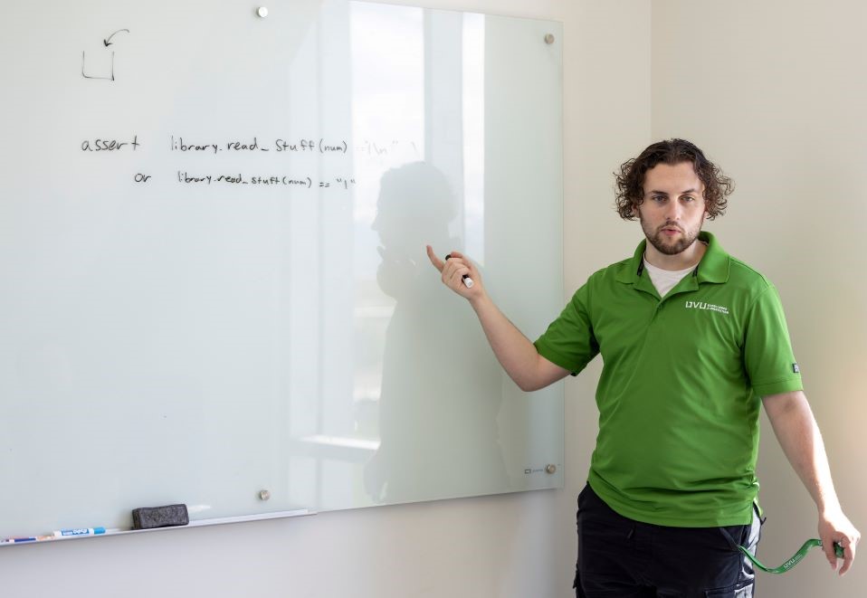 person pointing towards writing on a whiteboard