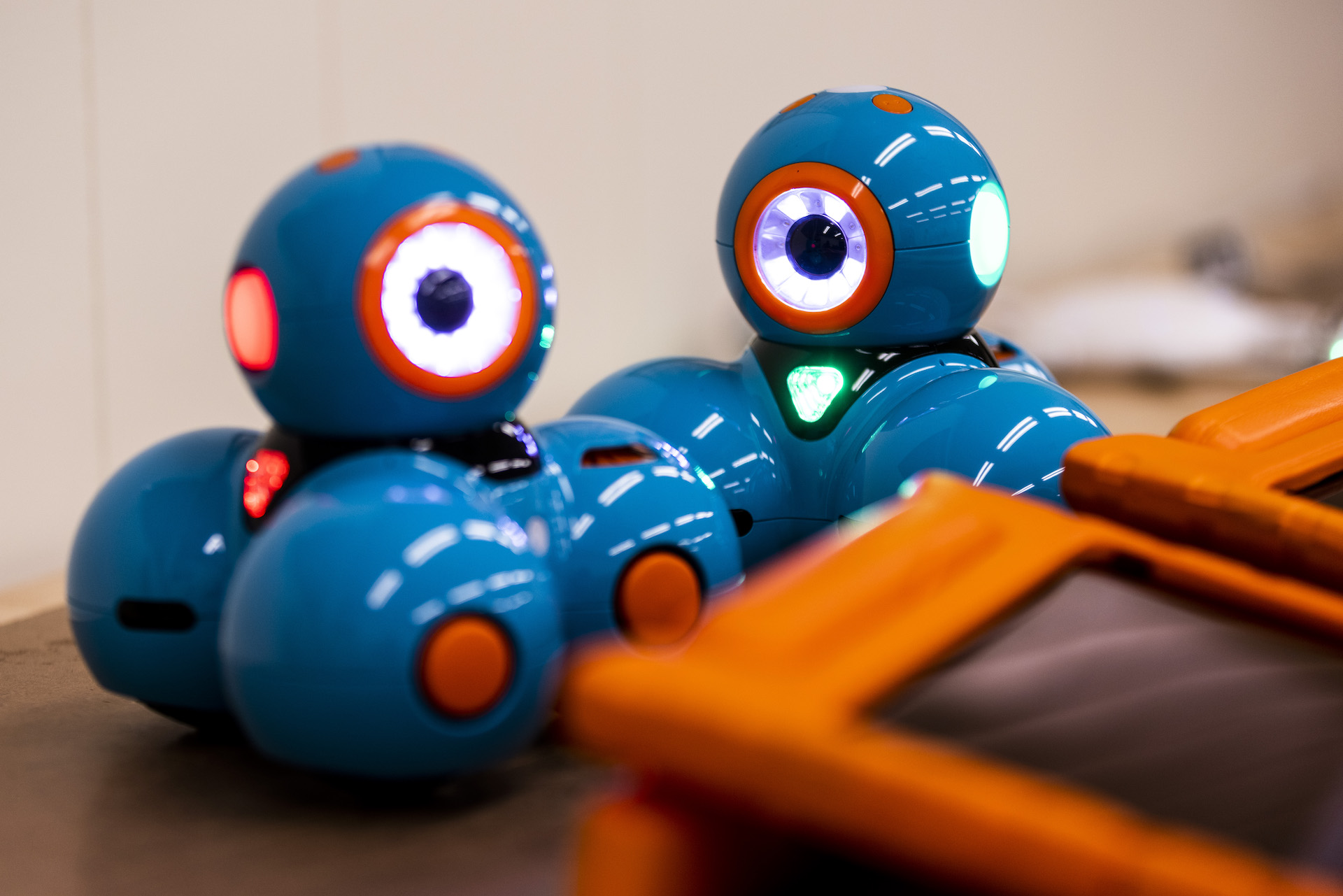 two Dash robots with their lights on