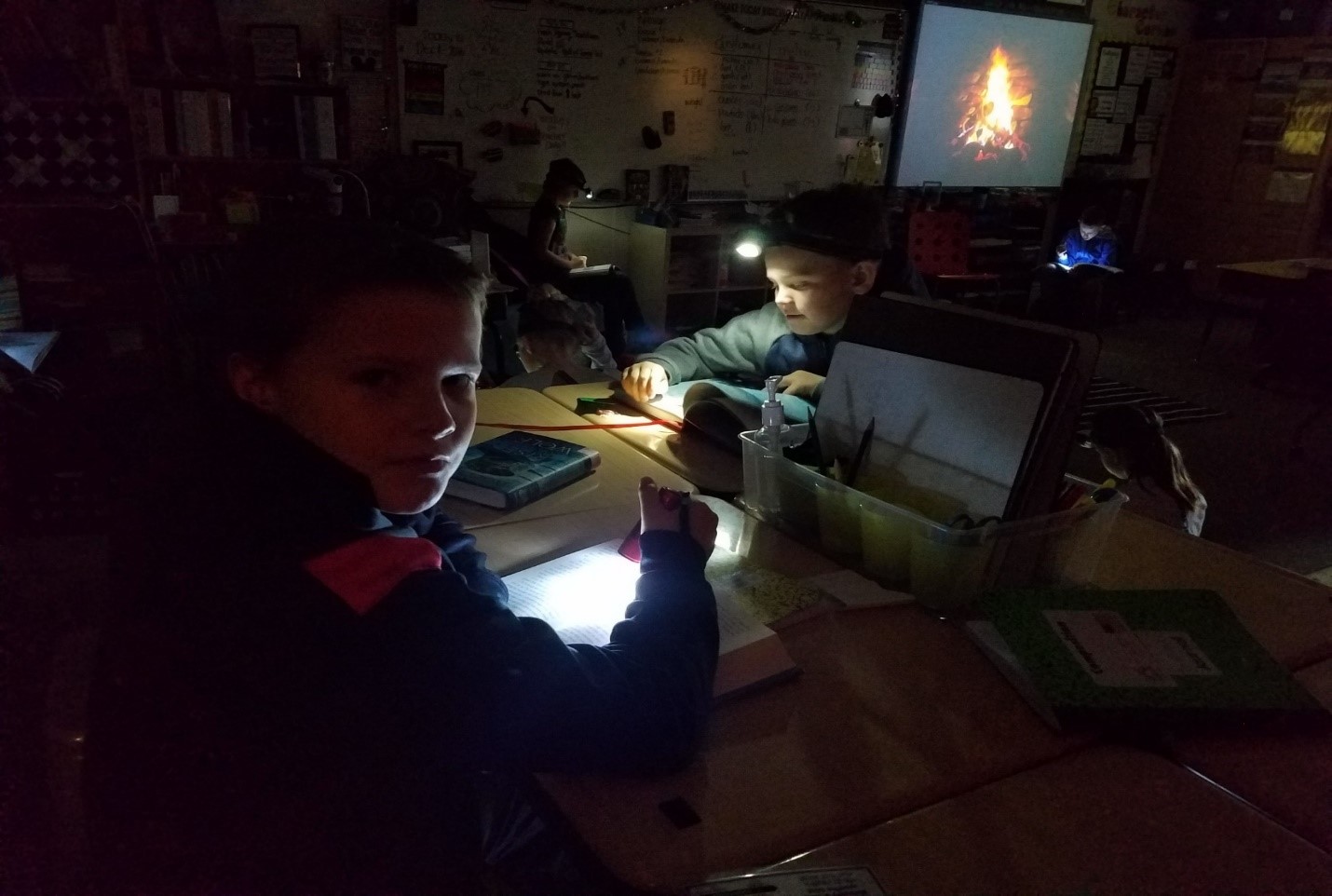 Students reading with a flashlight in the dark