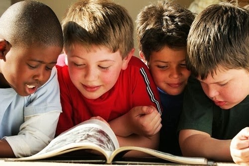 Group of boys reading a book together