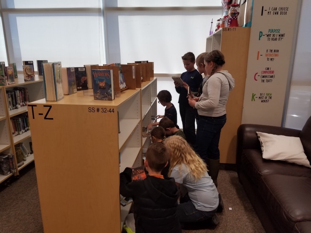Students picking out books at their library
