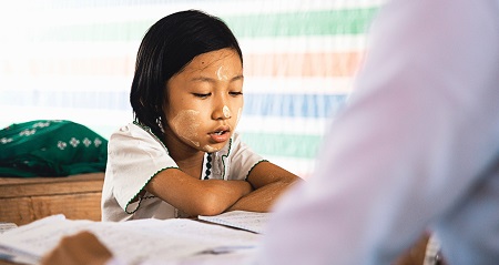 Child reciting from a book.