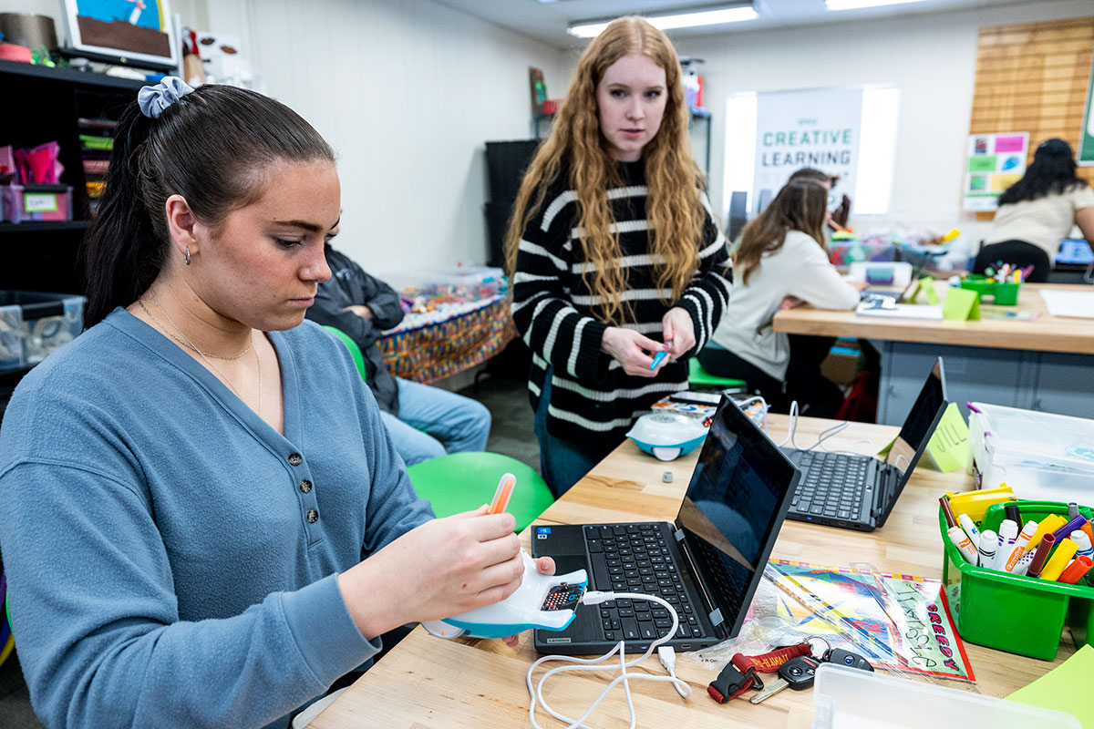 Image of people in a brightly lit classroom working on a project