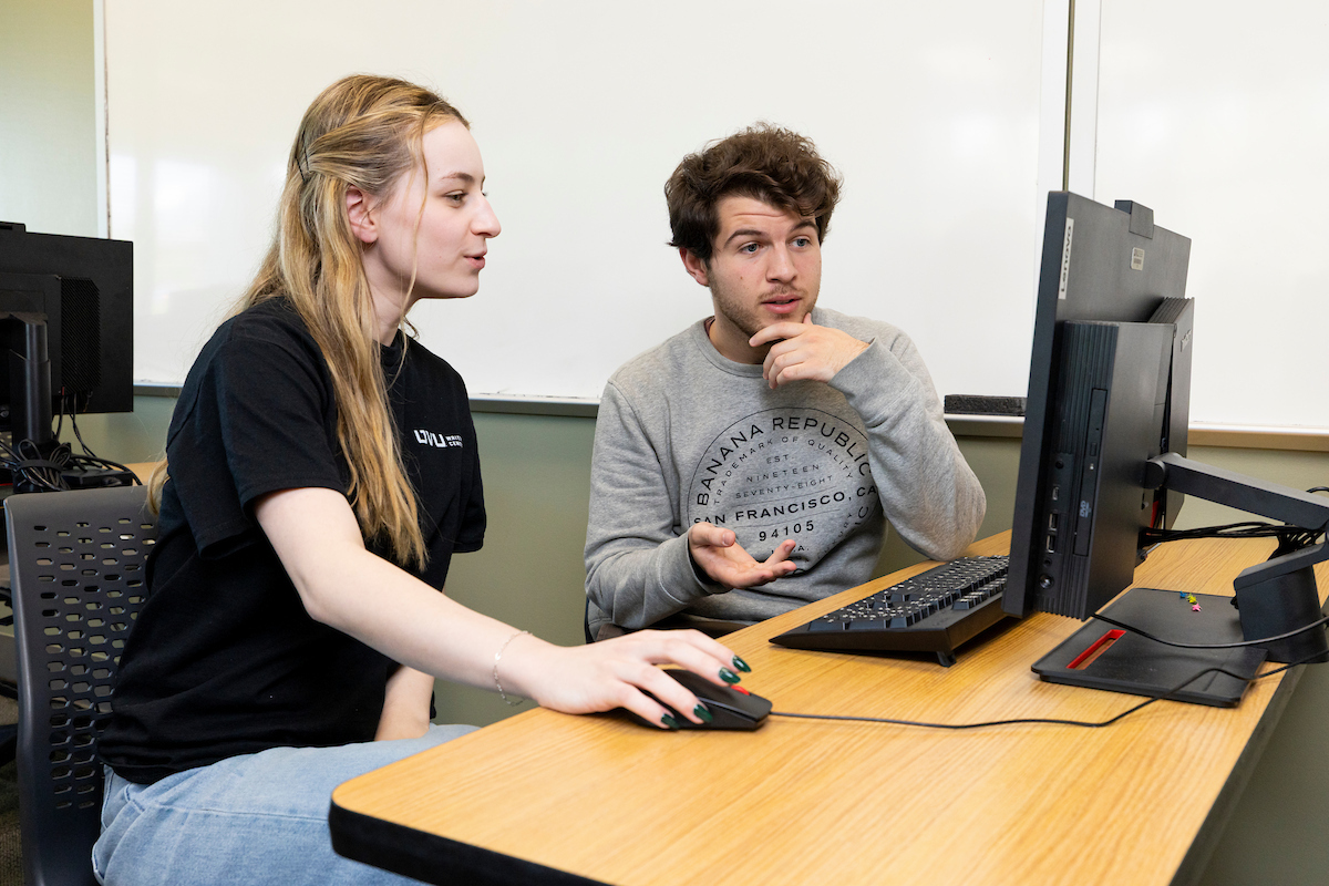 tutor helping a student on a computer