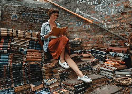 Woman reading on a pile of books