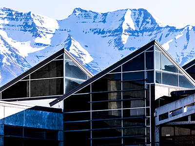 decorative image of UVU building with snow-covered mountains 