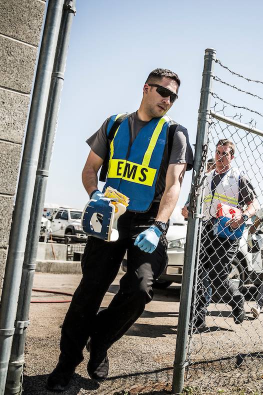 Man with EMS vest walking through fence opening