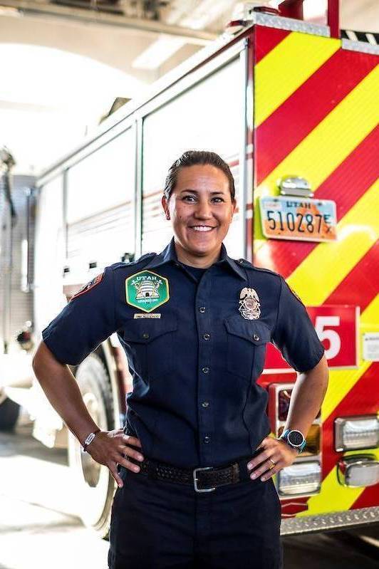 Female Advanced EMT/Paramedic posing in front of an ambulance