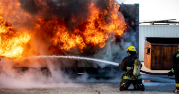 Firefighter putting out a fire with a hose