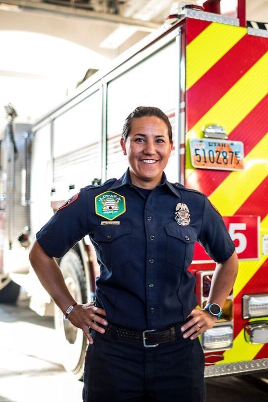 Femal EMT worker posing in front of an ambulance.