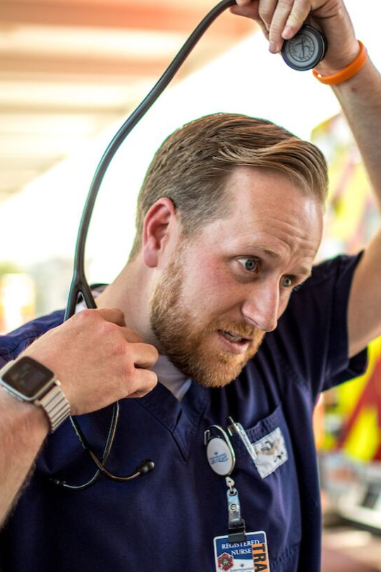 Male EMT worker taking a stethescope off his neck.