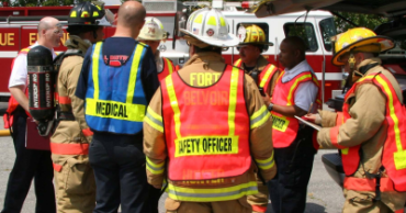 Emergency Services Personnel talking around a fire truck