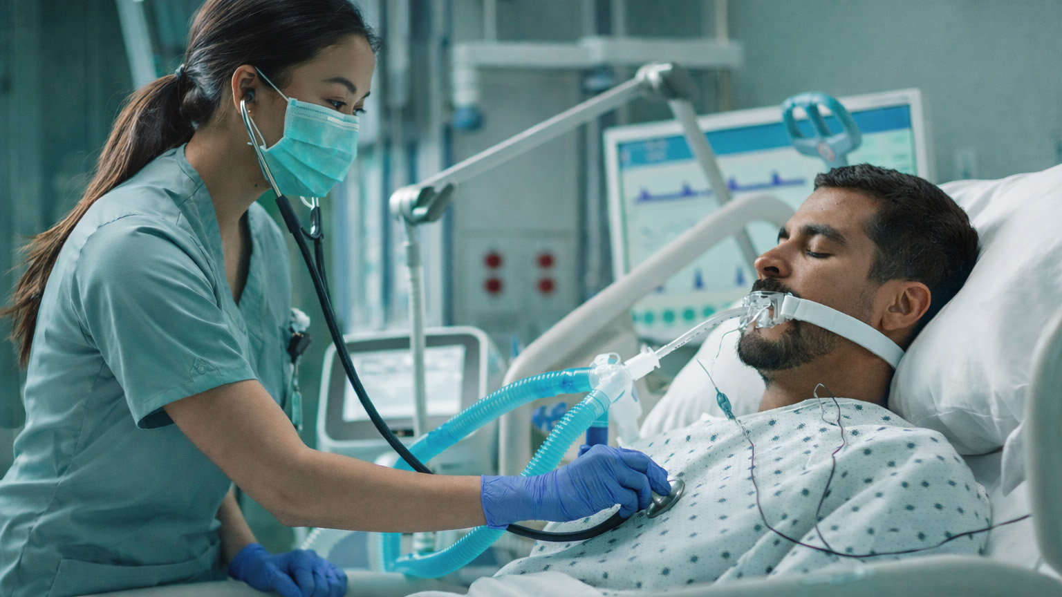 a nurse checking the breath sounds on a patient with a ventilator