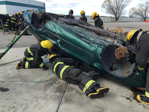 Firefighters work on an upsidedown car