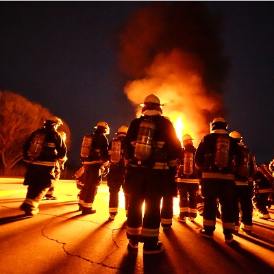 Firefighters heading into a burning building