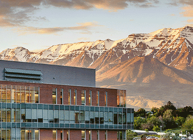 Photo of the Clarke building with mountains at sunset.