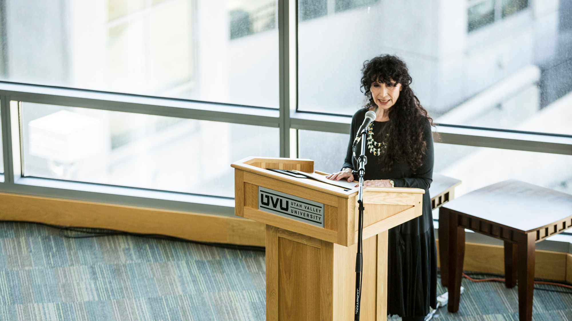 A woman lectures at a podium.