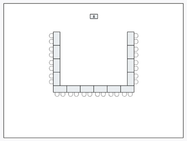 event space set up with rectangular tables in u-shape with chairs around the outside