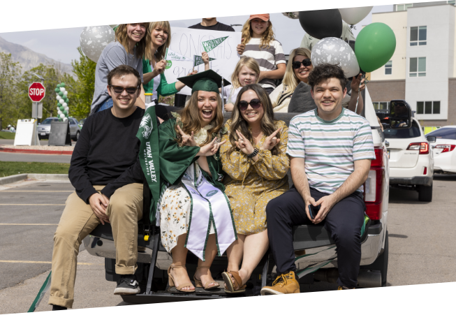graduate with family on the back tailgate of a truck