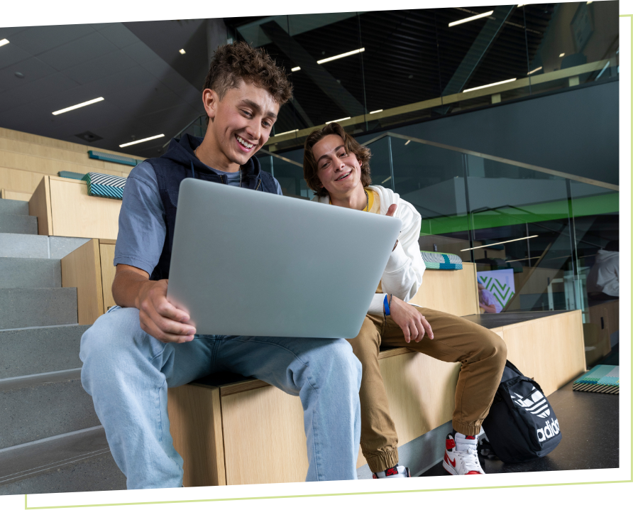 two students working on a laptop
