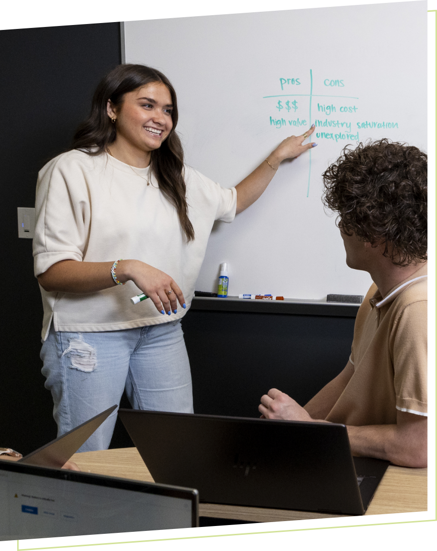 student presenting in group on whiteboard