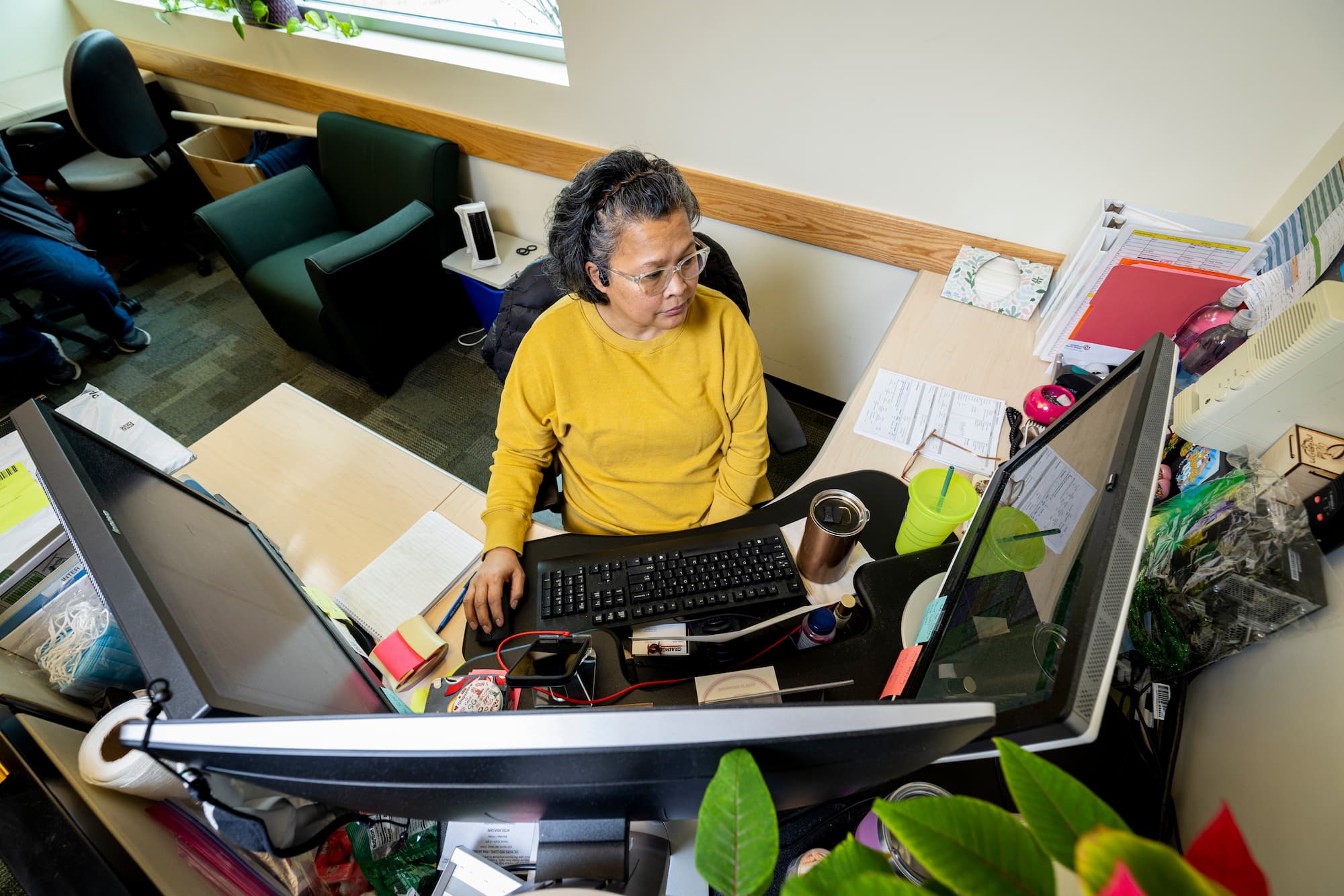 A photo of an admin smiling while sittting at a desk