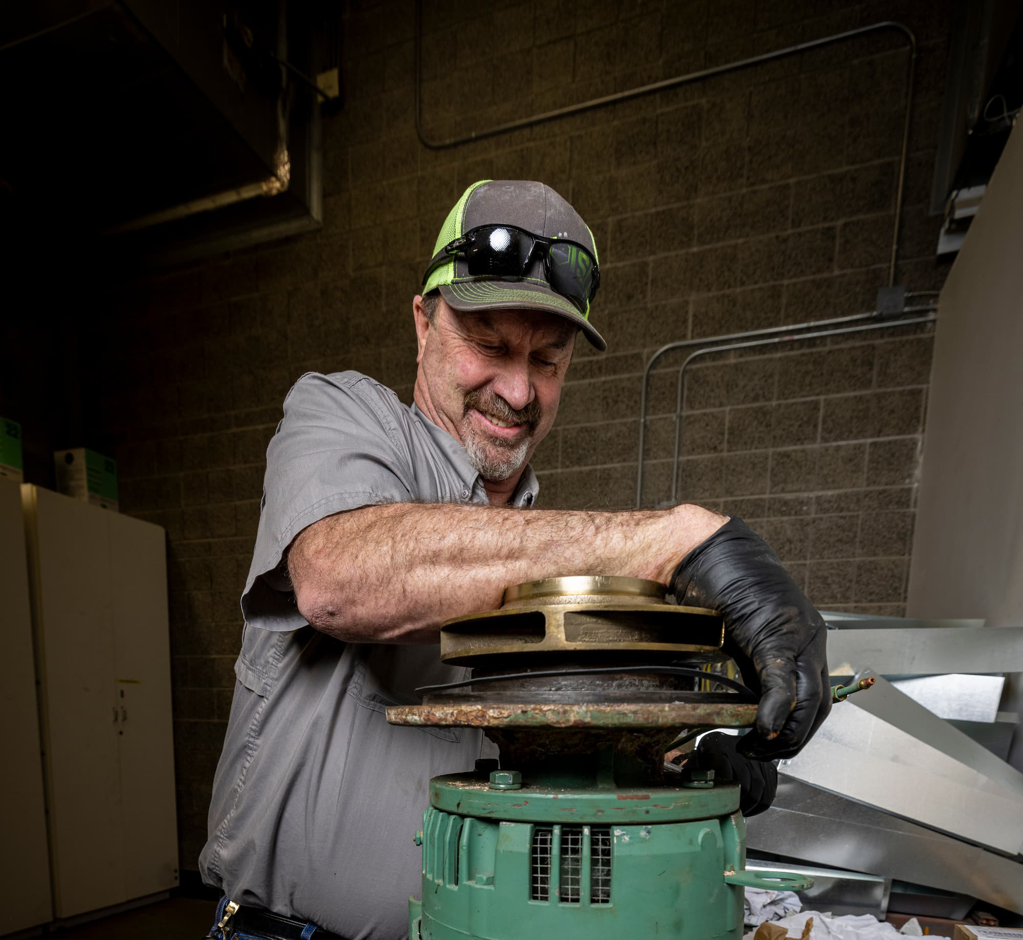 A man turning the top of some kind of pump-like device