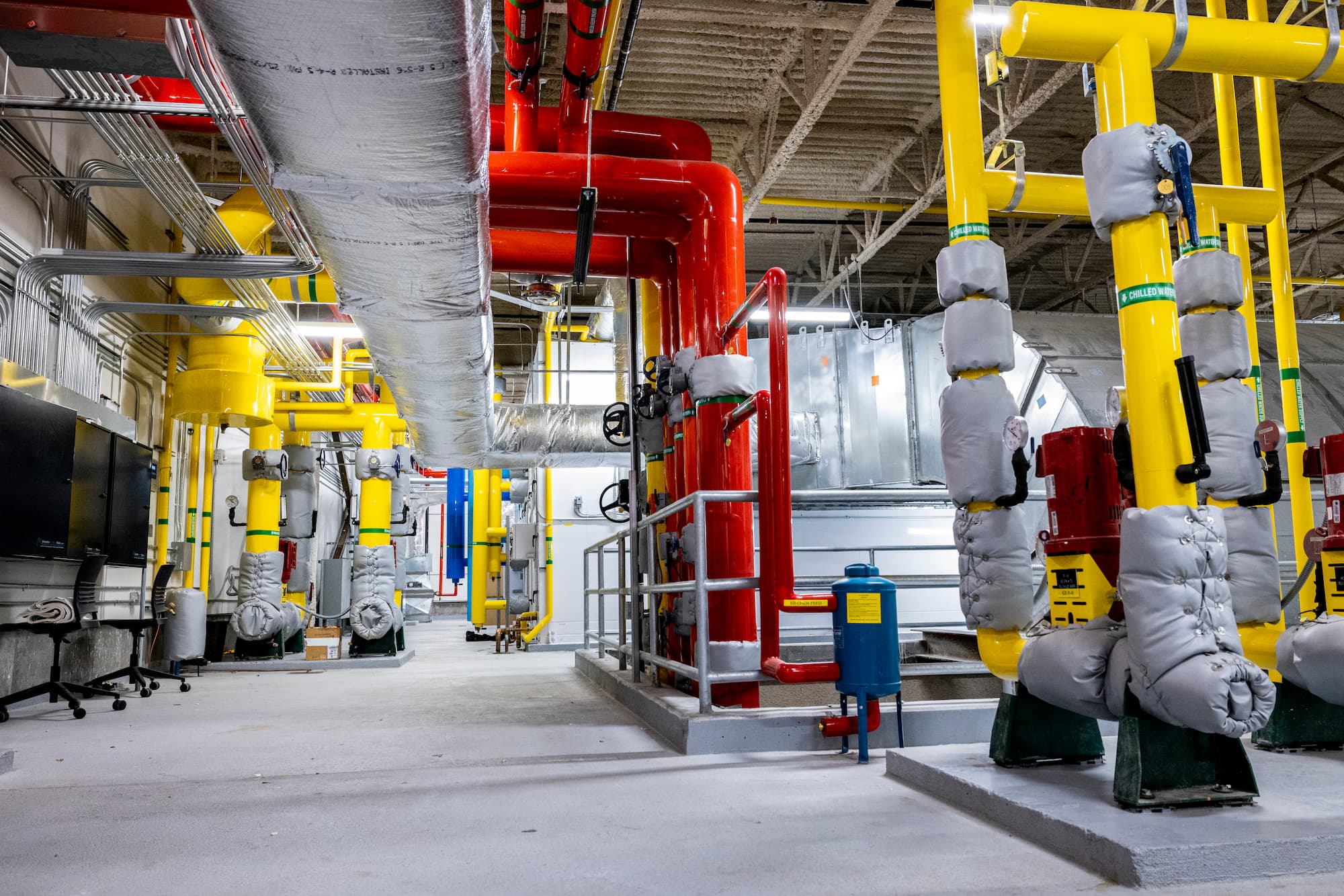 Photo of an HVAC room, with multicolored pipes spanning the entire room.