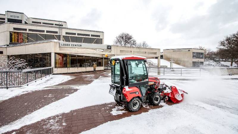 Snow plow clearing walkways.