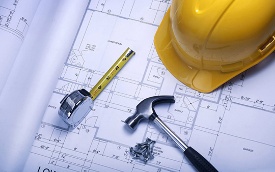 Image of a measuring tape, hard hat, hammer, nails, and a construction plan