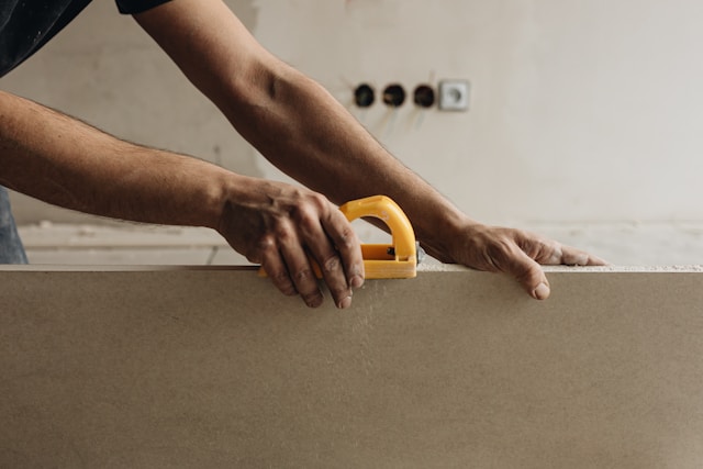Someone cutting boards with a handsaw