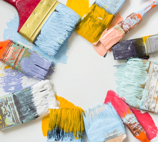 different size paintbrushes with different paints on them in a circle