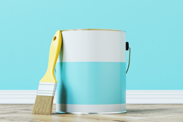 generic paint bucket with a paint brush proped up next to it