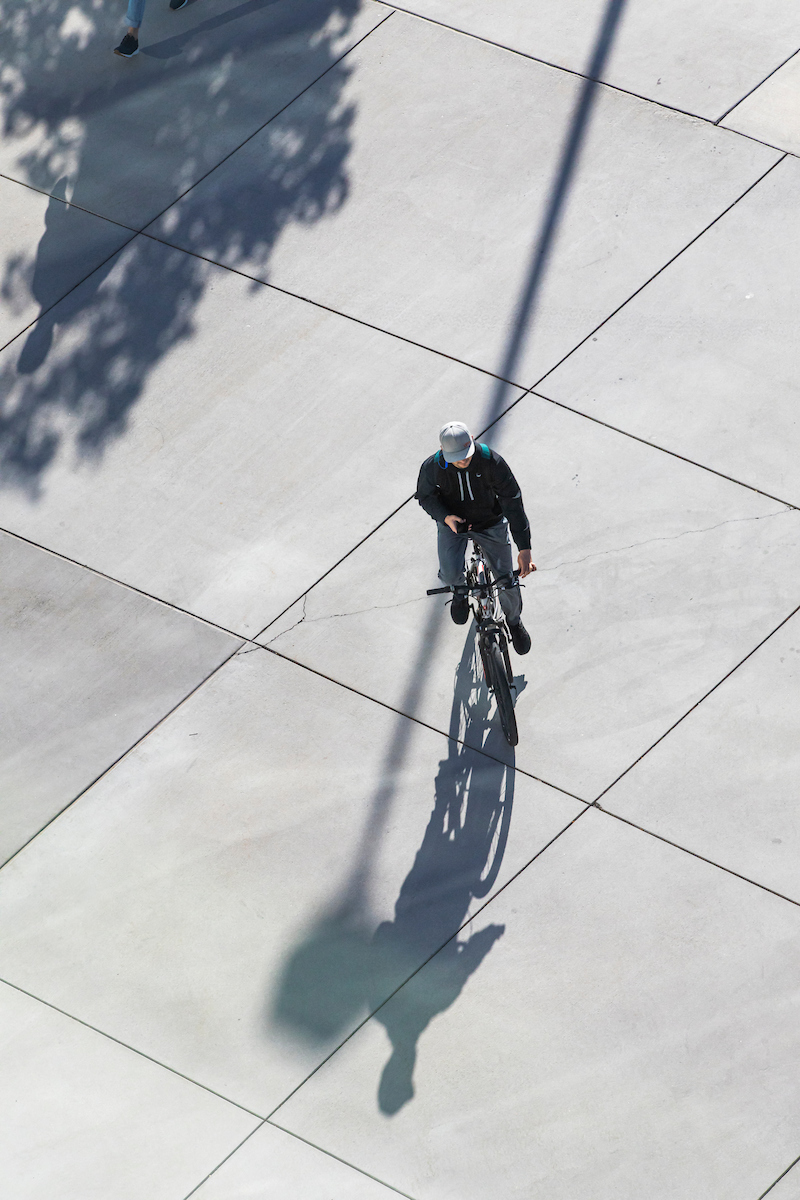 Person riding a bicycle on UVU campus.