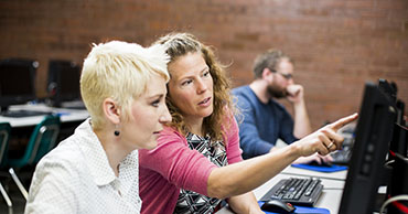 Two people working together on a computer.