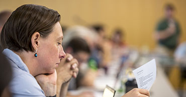 A senate committee member looking at a paper