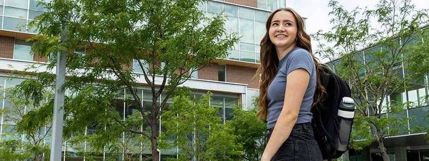 A female student walking outside on UVU's main campus.
