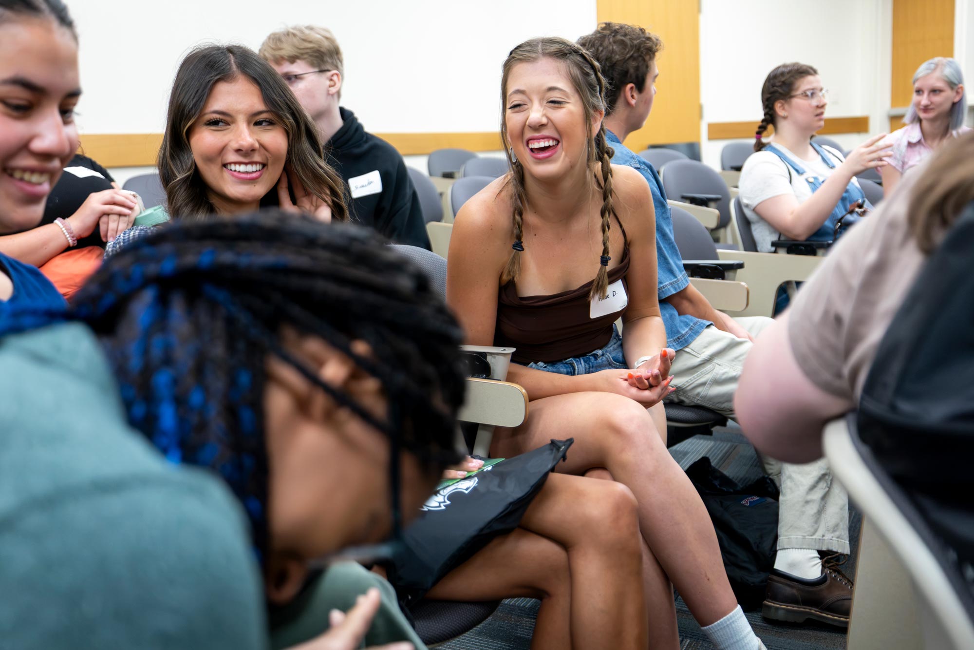 Students sitting in a group laughing and talking.