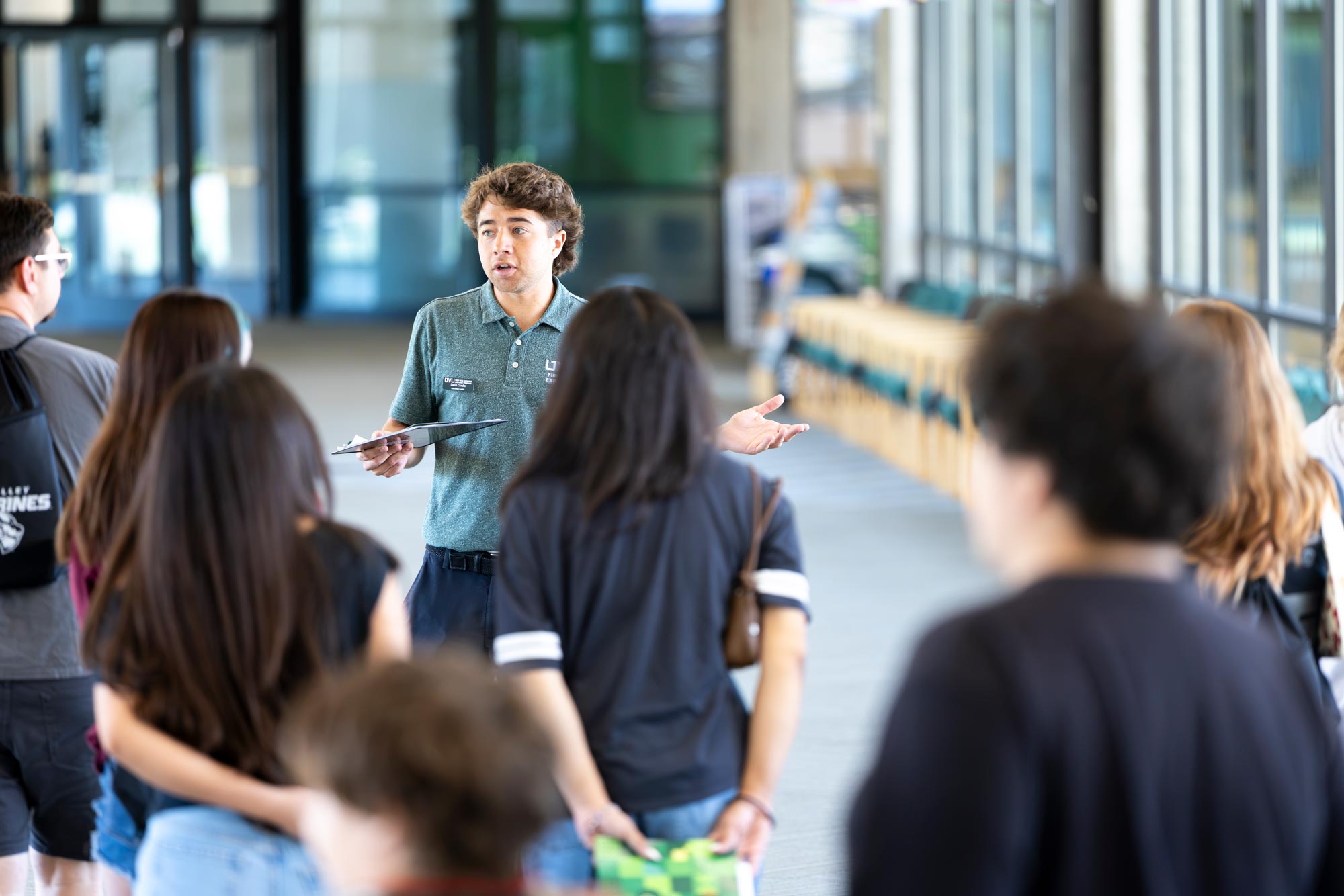 Students follow a tour guide giving them a tour of UVU.