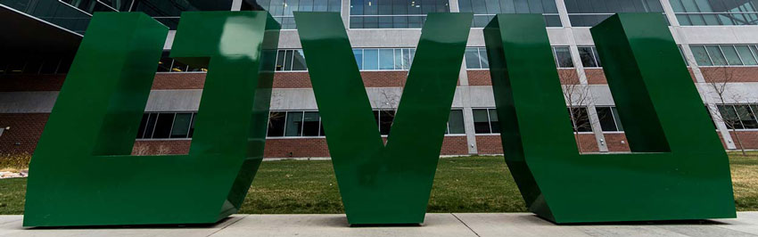 A large sign made of the individual UVU letters that is painted green.