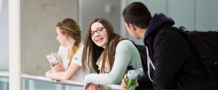 Two students converse happily at a college campus