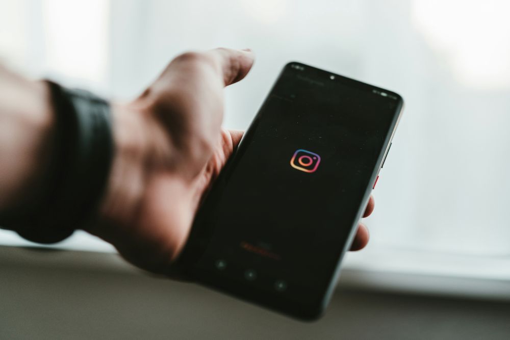person holding a phone, with the instagram app open