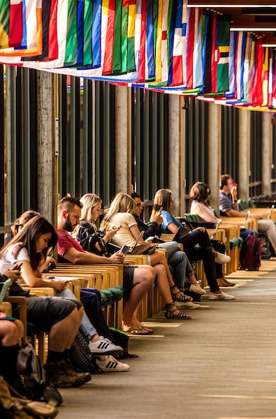 Students sitting in chairs along the walls of UVU's Hall of Flags 