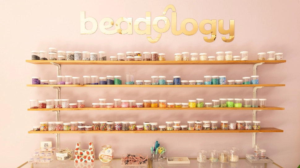 Beadology - shelves featuring containers of multicolored beads.